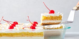 creamy coconut lime cheesecake layered with buttery shortbread cookies, crushed pineapple jello, cool whipped cream, and maraschino cherries all on a graham cracker coconut crust