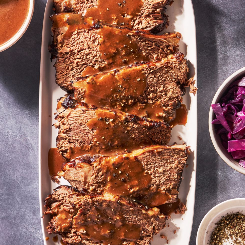 sauerbraten on a plate with a bowl of red cabbage on the side