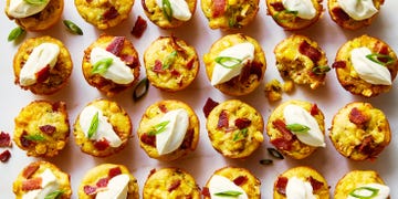 loaded cheesy corn bites topped with sour cream, sliced scallions, and bacon