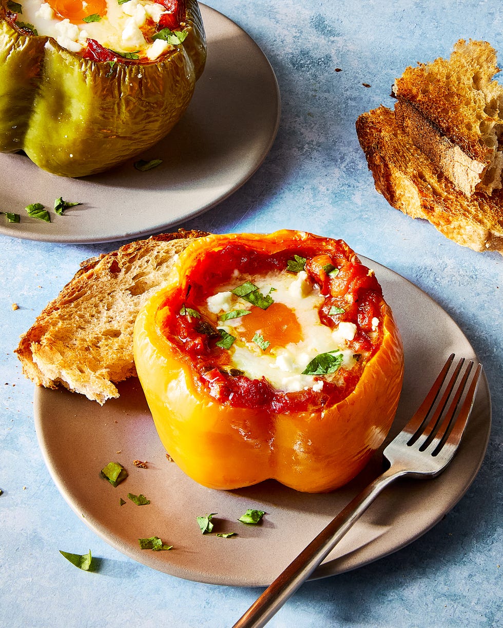 shakshuka stuffed pepper on a white plate with a fork and a piece of toast
