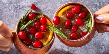 cranberry orange mule served in copper mugs and garnished with fresh cranberries, orange slices, and rosemary sprigs