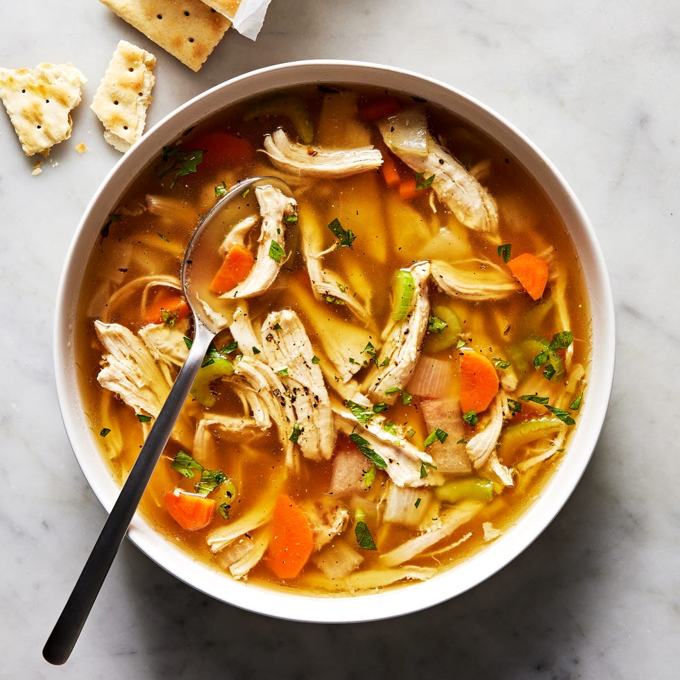 chicken soup in a bowl with saltines on the side