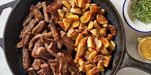 a skillet of crispy potatoes and tender, seared flank steak bathed in a tangy, savory garlic mustard butter sauce