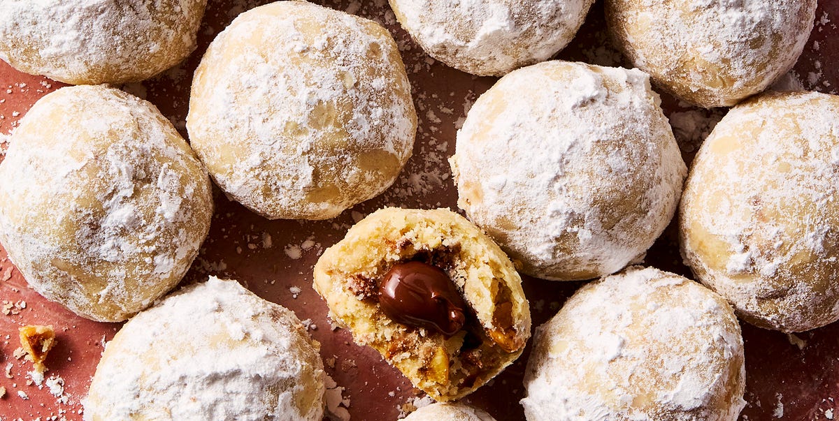 Nutella Stuffed Snowball Cookies round hazelnut shortbread cookies coated in powdered sugar with nutella in the center of each cookie