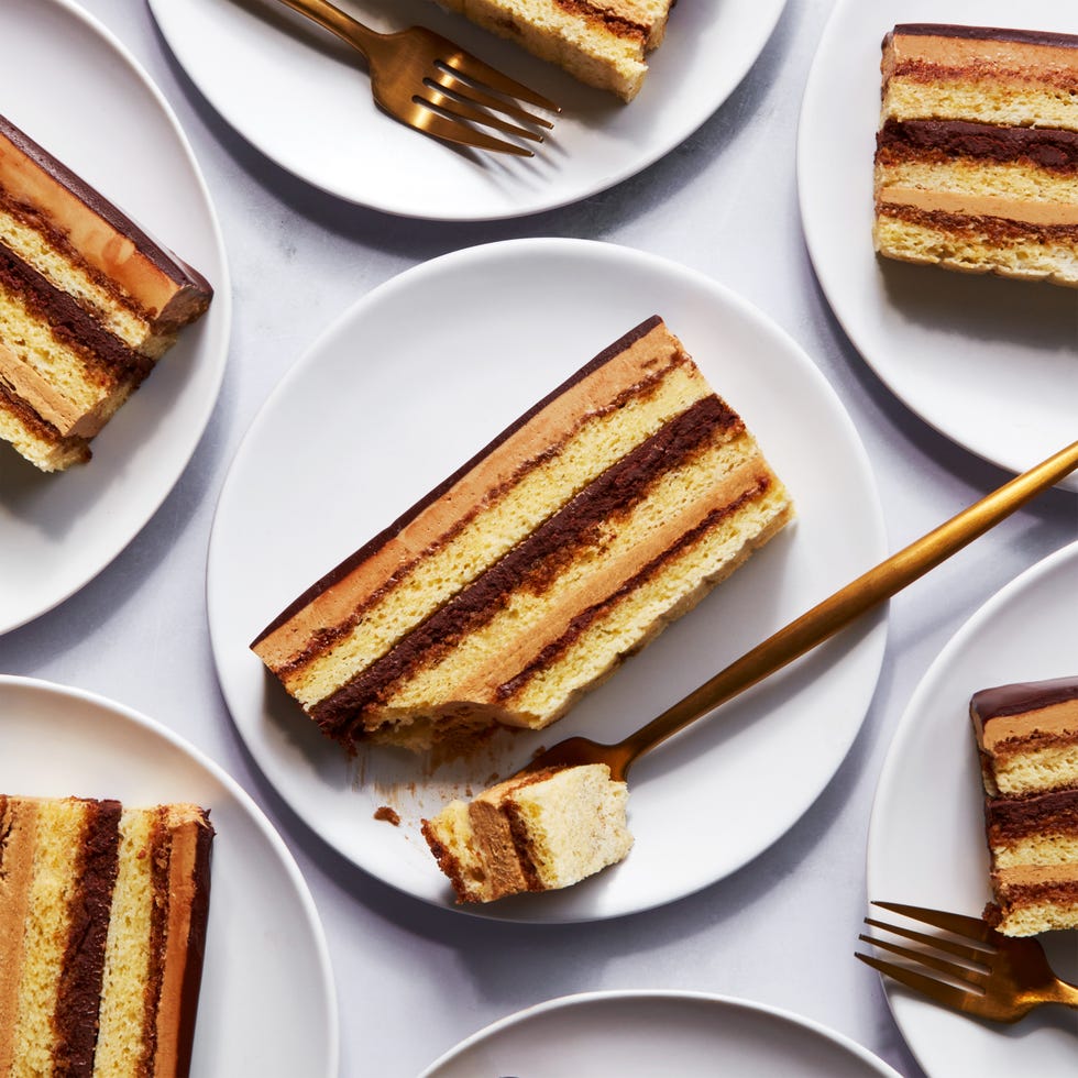 slices of opera cake on plates with gold forks