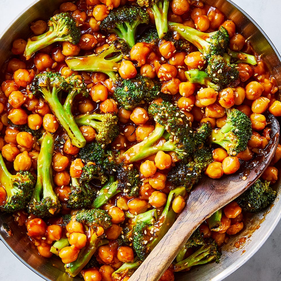 sticky sesame chickpeas and broccoli in a pan with a wooden spoon