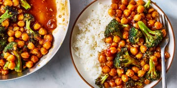 sticky sesame chickpeas and broccoli on a plate with rice beside a pan with more sticky sesame chickpeas and broccoli