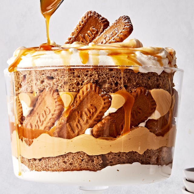 Biscoff Trifle a trifle dish filled with layers of spice cake, caramel, cookie butter mousse, whipped cream, and biscoff cookies