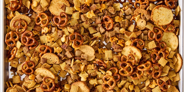 a bowl of homemade chex mix with pretzels, chex cereal, goldfish, and bagel chips