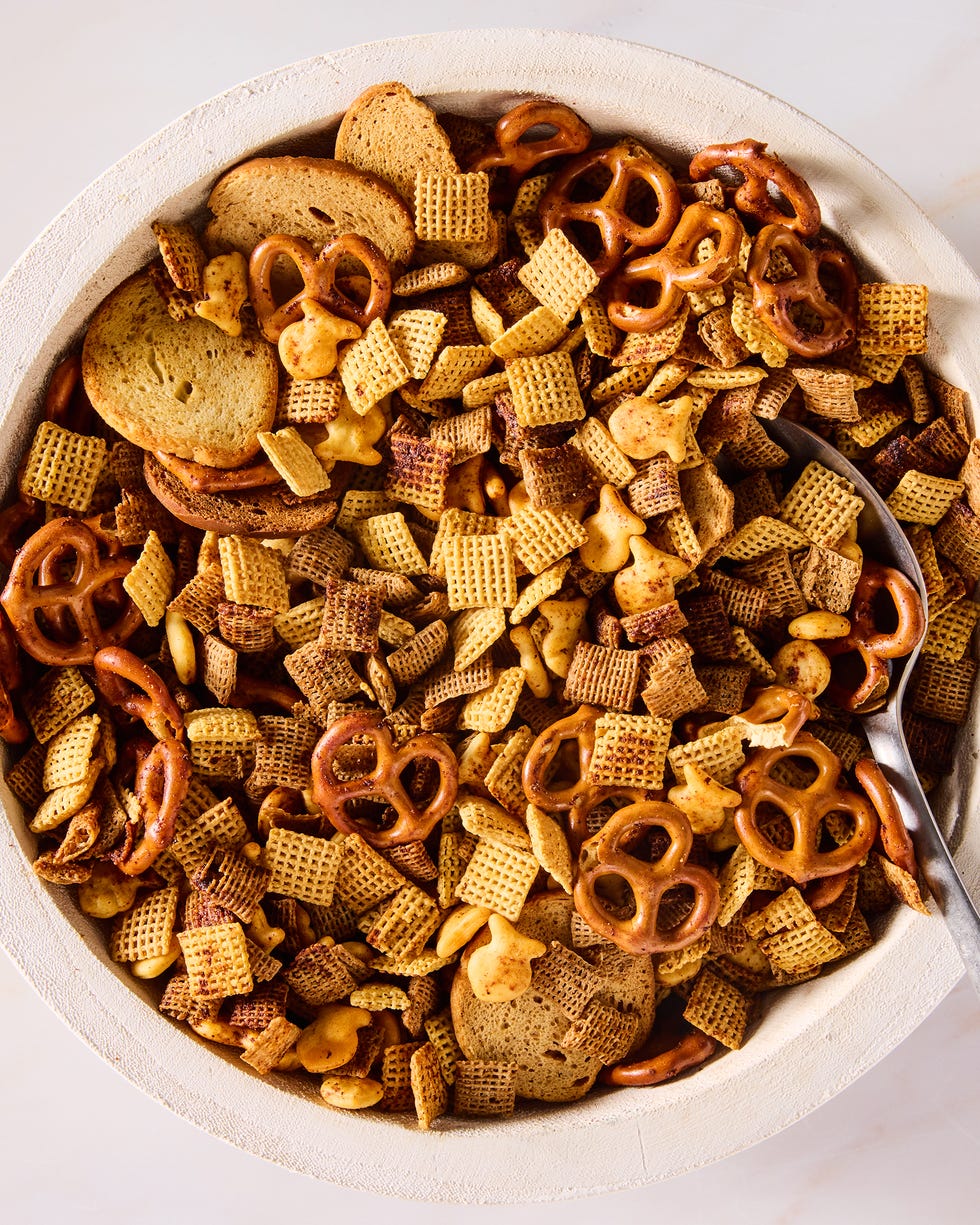 a bowl of homemade chex mix with chex cereal, pretzels, goldfish, and bagel chips