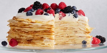 crepe cake topped with whipped cream and berries