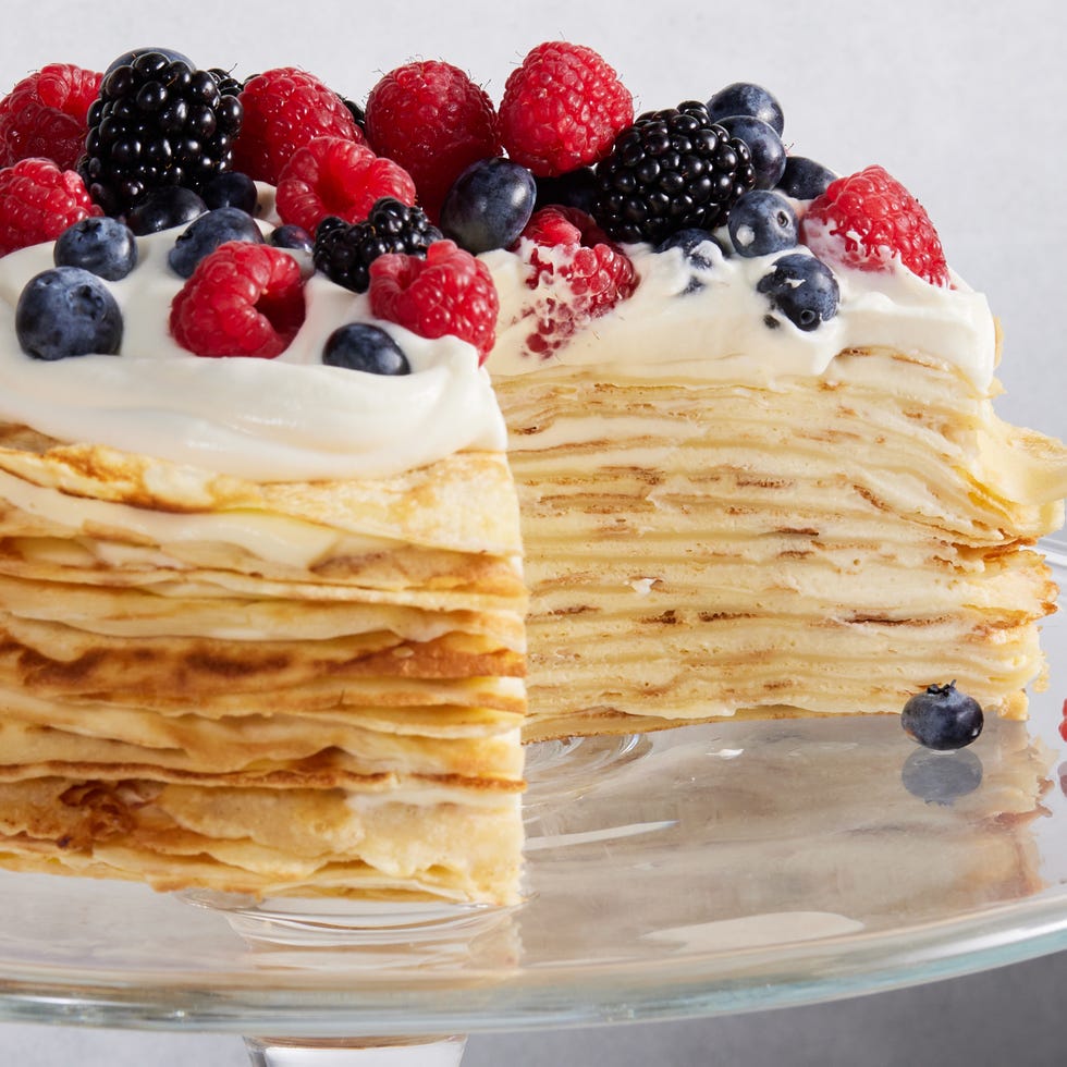crepe cake topped with whipped cream and mixed berries