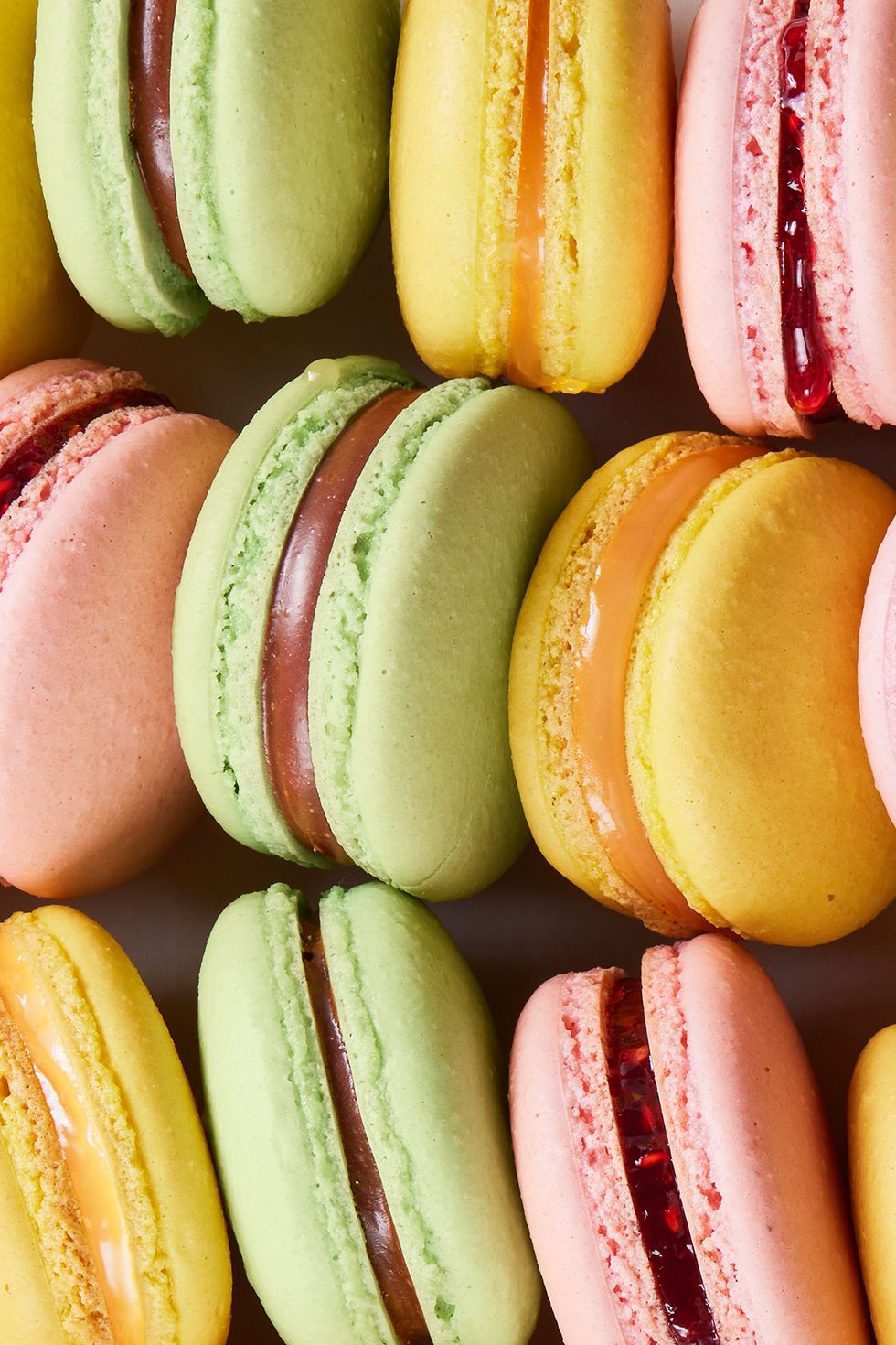 yellow, pink, and green macarons lined up together
