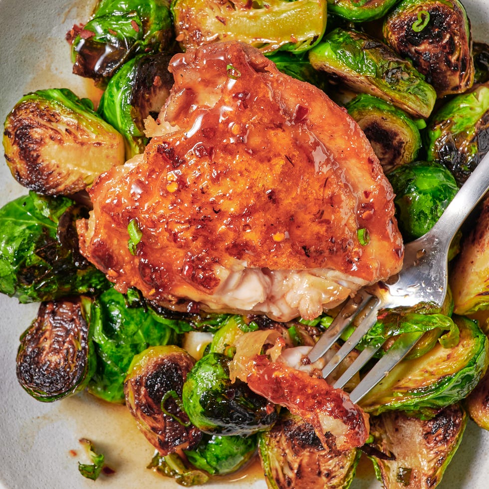 Poulet au miel chaud et choux de Bruxelles dans une assiette, à la fourchette.