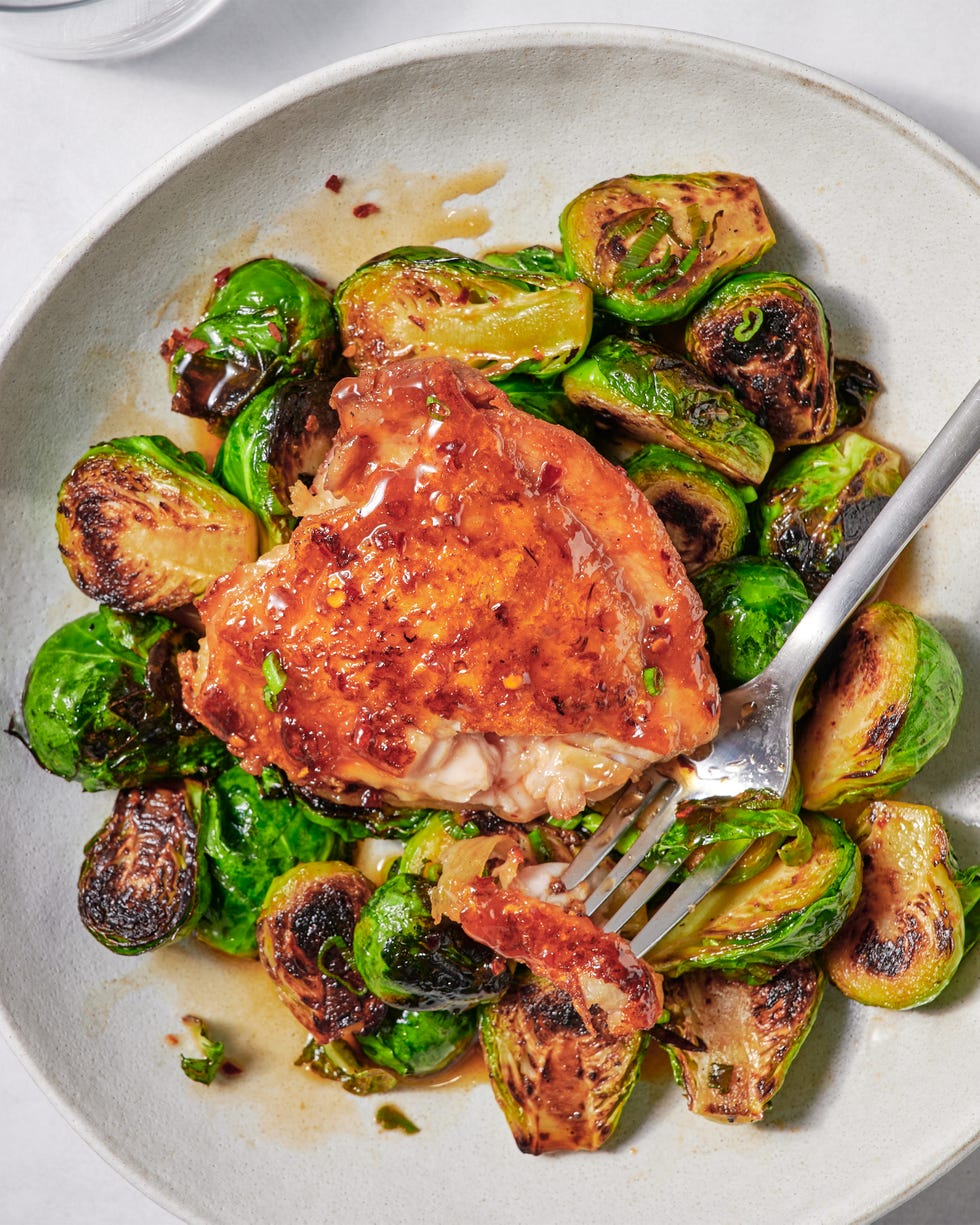 one pan hot honey chicken and brussels sprouts on a plate with a fork