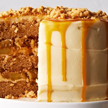 salted caramel apple crumble cake topped with caramel and crumbles on a cake stand