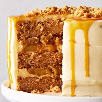 salted caramel apple crumble cake topped with caramel and crumbles on a cake stand