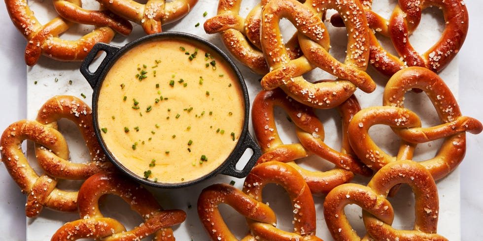 beer cheese in a black pot topped with chives, surrounded with soft pretzels