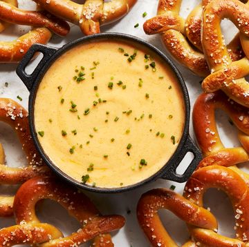 beer cheese in a black pot topped with chives, surrounded with soft pretzels