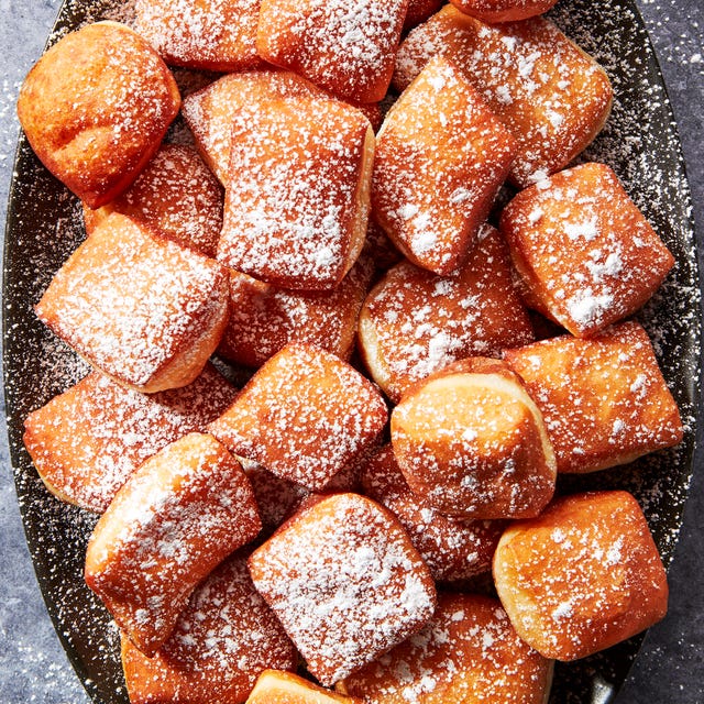 Beignets beignets on a platter dusted with powdered sugar