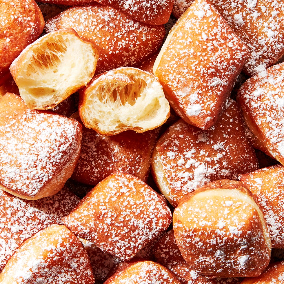 beignets on a platter dusted with powdered sugar