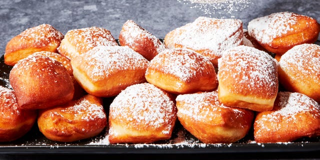 beignets on a platter dusted with powdered sugar