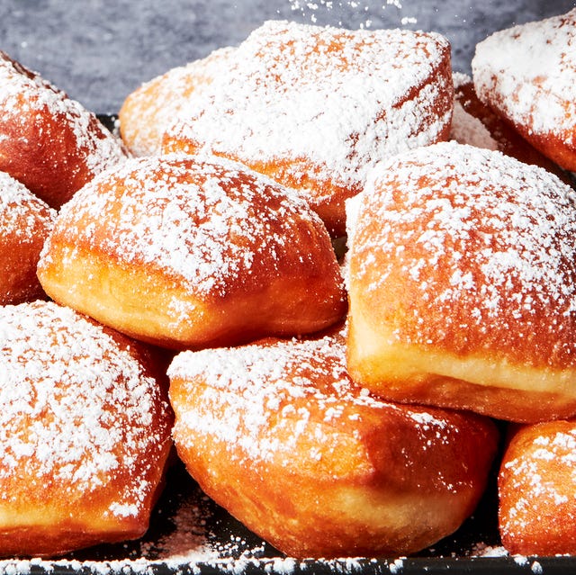 Beignets beignets on a platter dusted with powdered sugar