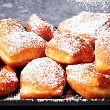 beignets on a platter dusted with powdered sugar