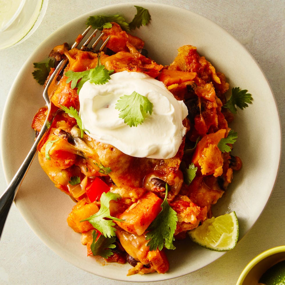 black bean sweet potato taco skillet serving on a plate topped with sour cream and cilantro