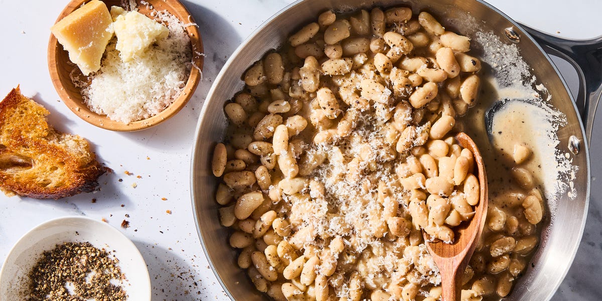Cacio e pepe white beans skillet cacio e pepe white beans skillet with a wooden spoon beside a plate of cheese