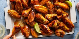 coconut lime chicken wings on a tray with lime wedges
