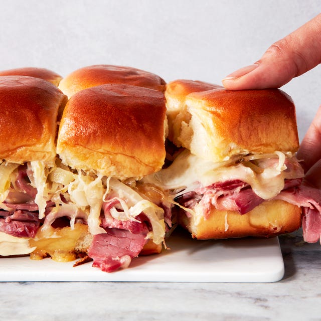 Corned Beef Sliders a plate of sliders made with hawaiian rolls, corned beef, sauerkraut, and melted swiss cheese