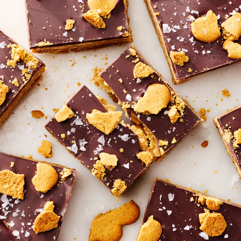 a gingerbread millionaire shortbread bar broken apart, surrounded by other bars