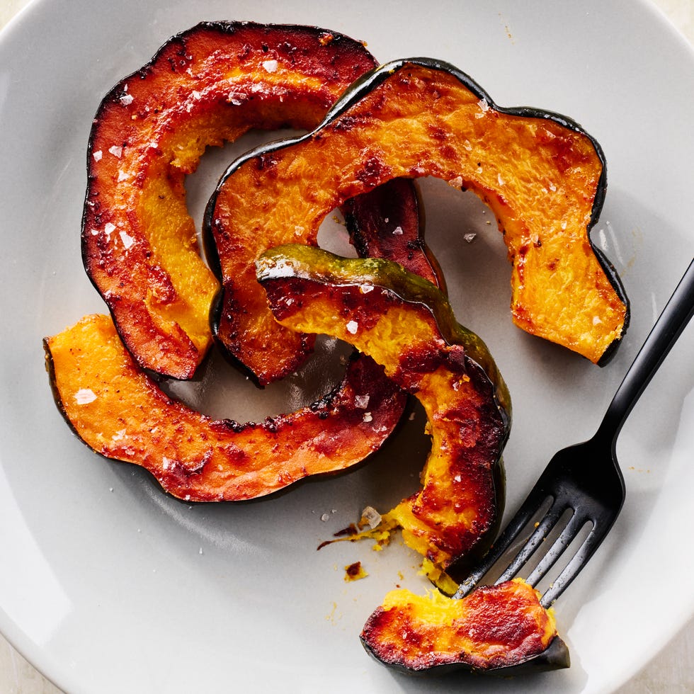 acorn squash on a white plate with a fork