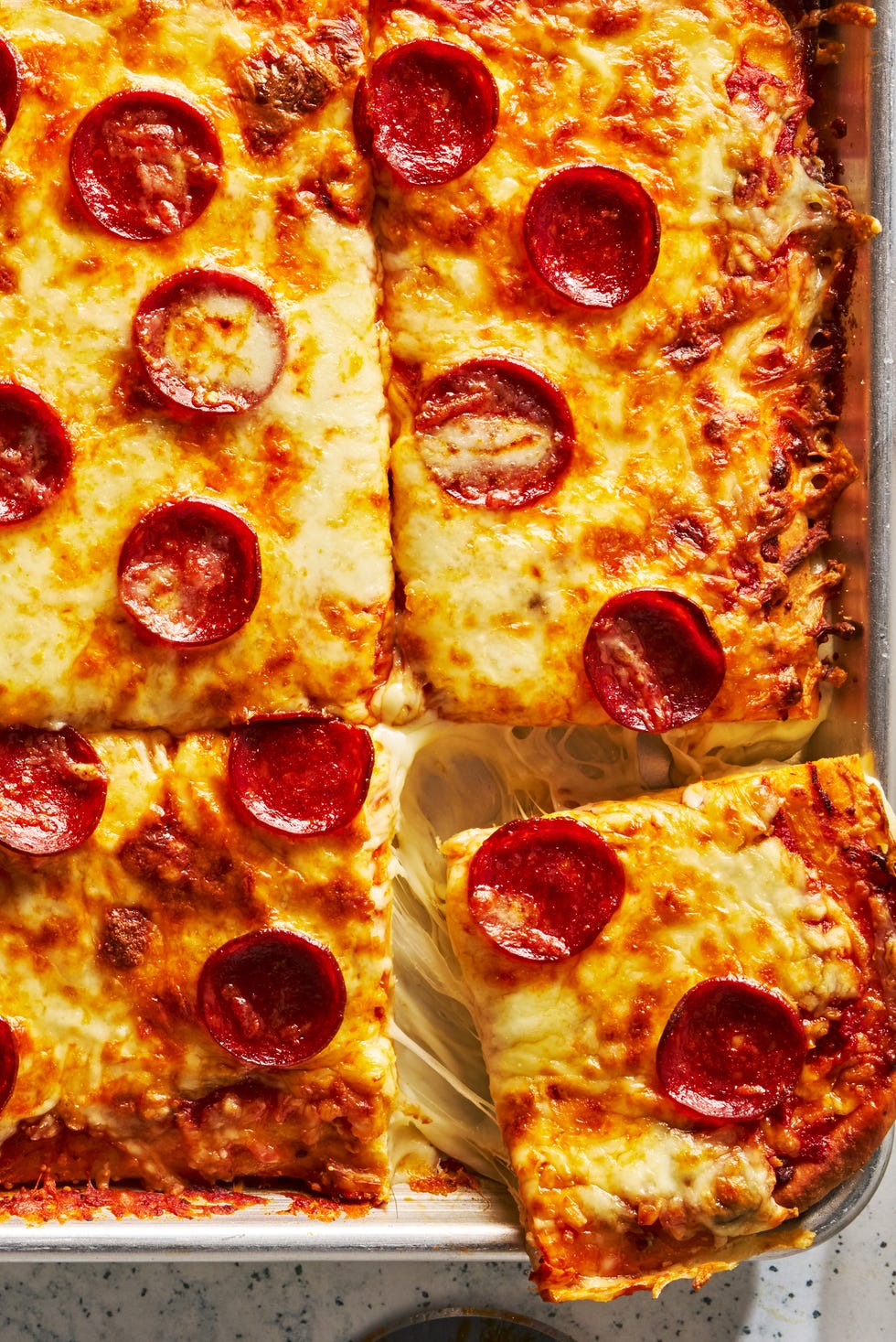 Lunch Lady Sheet Pan Pizza herby pizza sauce, melty mozzarella, and spicy pepperoni baked on that signature thick and fluffy crust and topped with a sprinkle of italian seasoning