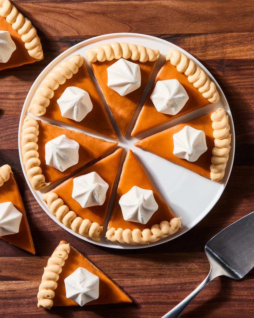 triangular spiced shortbread cookies coated in orange icing, beige frosting, and a vanilla meringue cookie