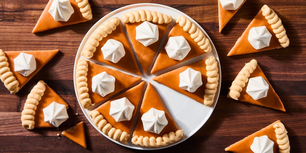 triangular spiced shortbread cookies coated in orange icing, beige frosting, and a vanilla meringue cookie