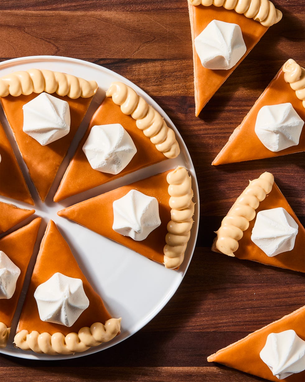 triangular spiced shortbread cookies coated in orange icing, beige frosting, and a vanilla meringue cookie