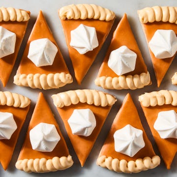 triangular spiced shortbread cookies coated in orange icing, beige frosting, and a vanilla meringue cookie