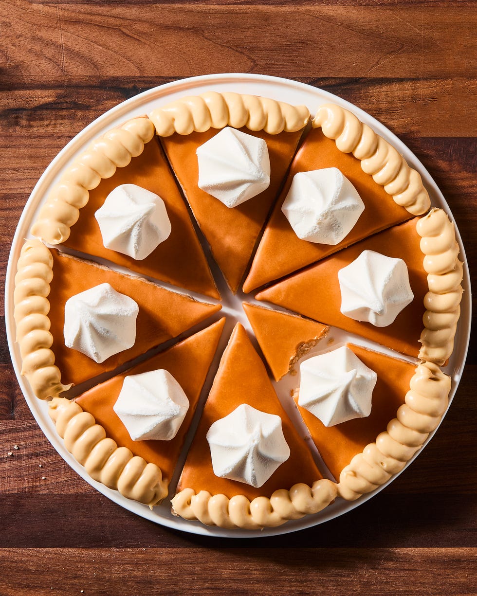 triangular spiced shortbread cookies coated in orange icing, beige frosting, and a vanilla meringue cookie