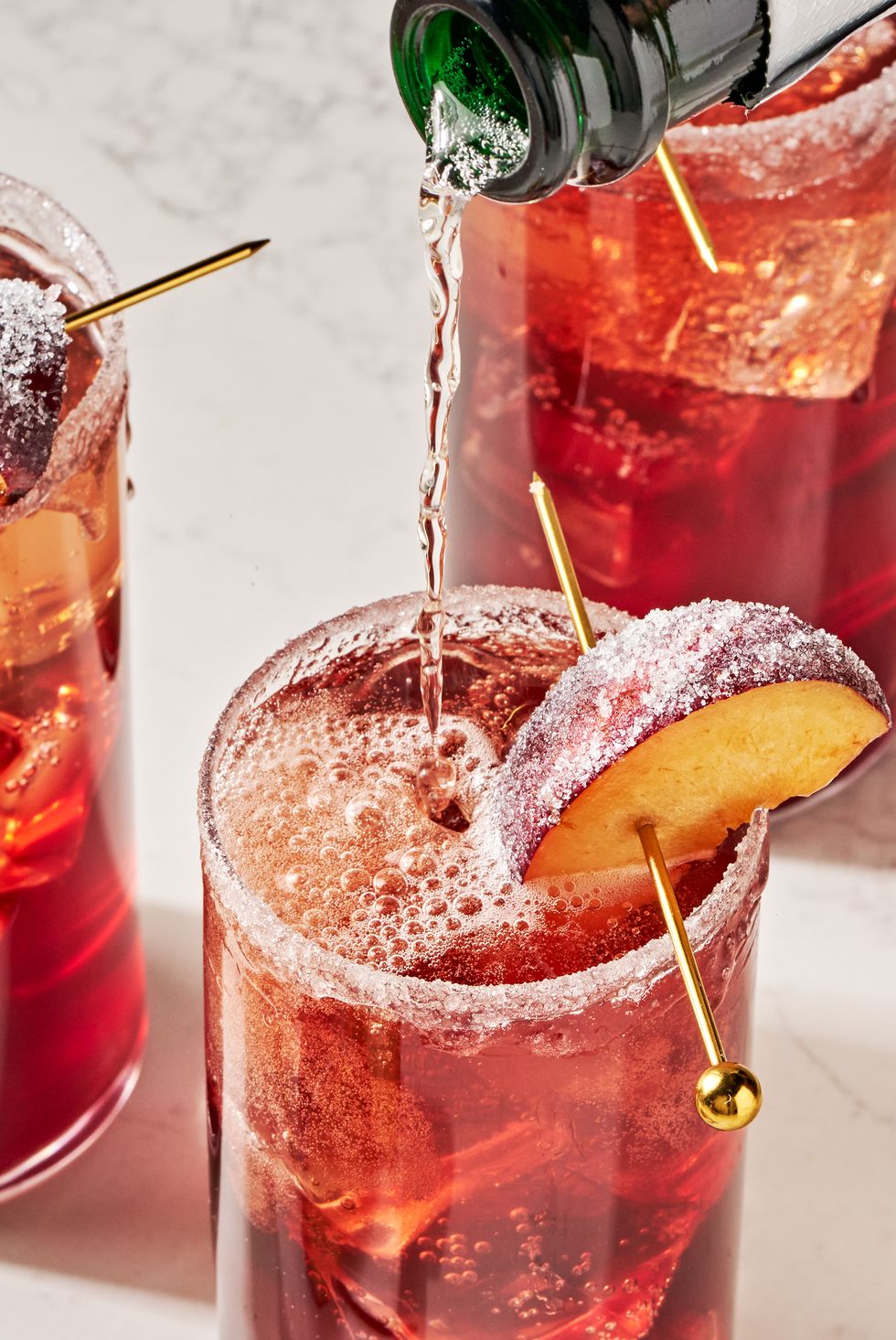 a refreshing holiday cocktail with plum wine, prosecco, maraschino cherry syrup, lemon, and bitters, garnished with a sugared plum