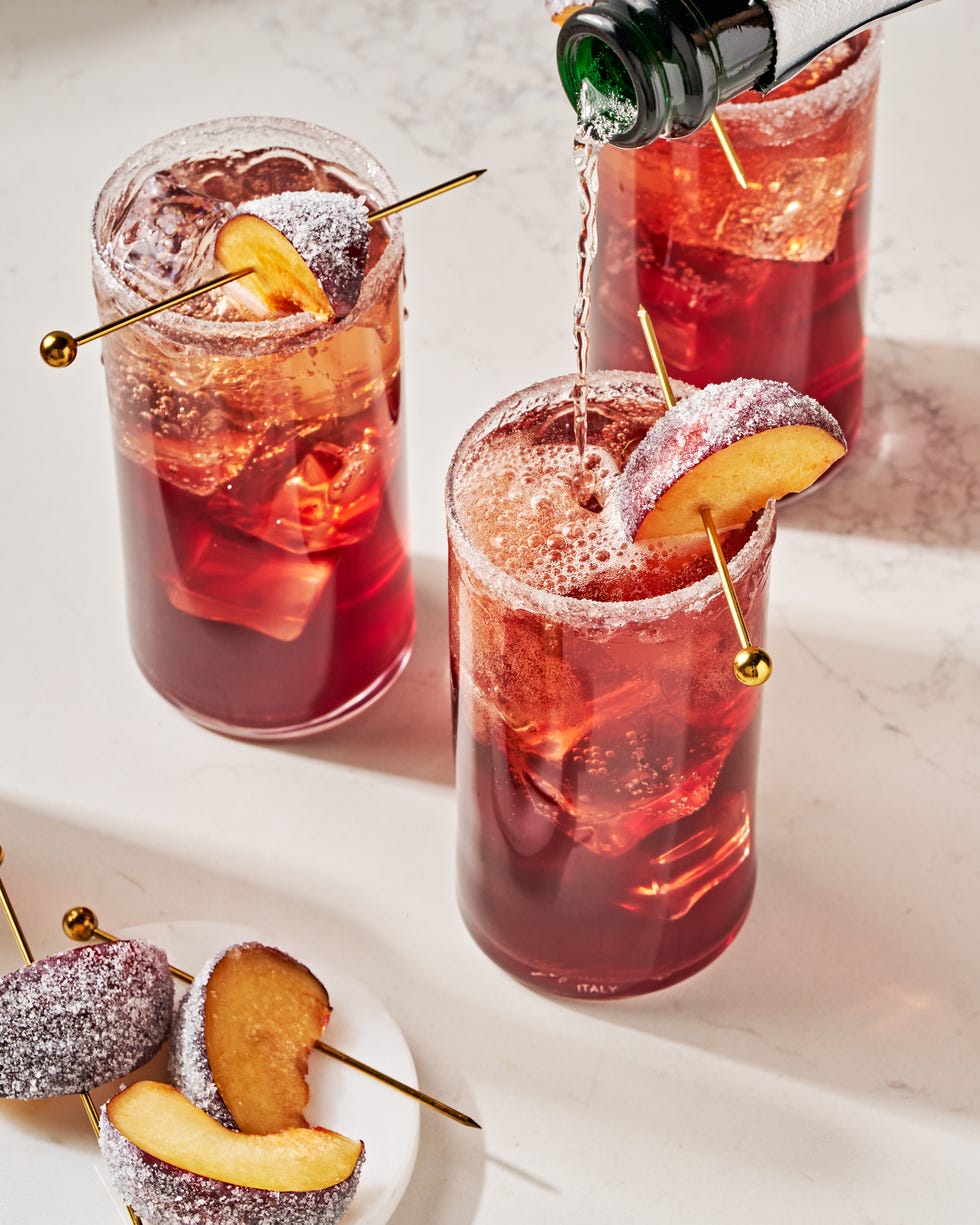 a refreshing holiday cocktail with plum wine, prosecco, maraschino cherry syrup, lemon, and bitters, garnished with a sugared plum