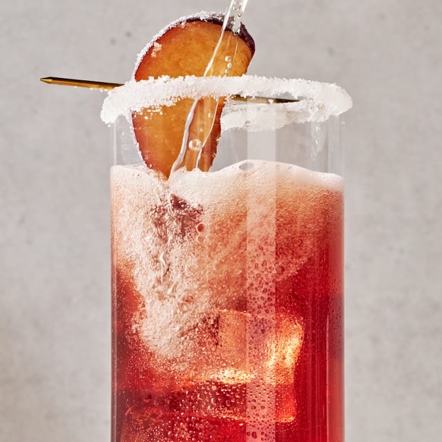 a refreshing holiday cocktail with plum wine, prosecco, maraschino cherry syrup, lemon, and bitters, garnished with a sugared plum