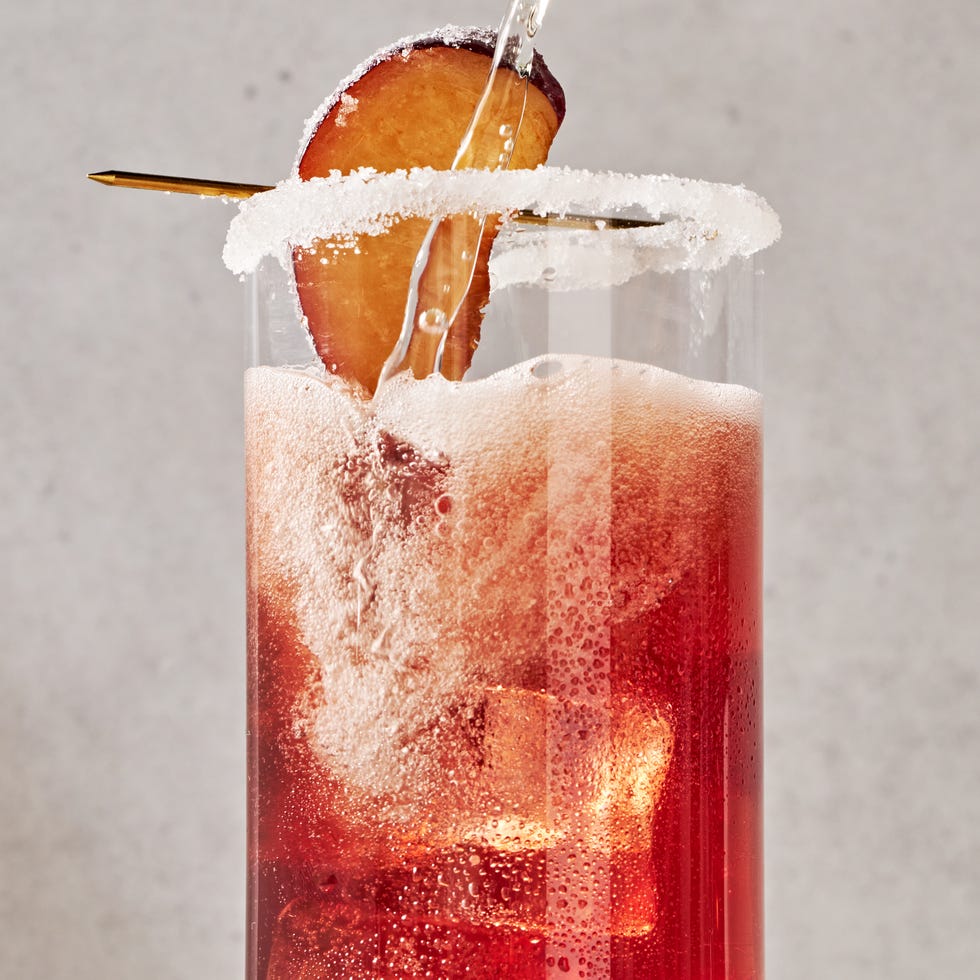 a refreshing holiday cocktail with plum wine, prosecco, maraschino cherry syrup, lemon, and bitters, garnished with a sugared plum