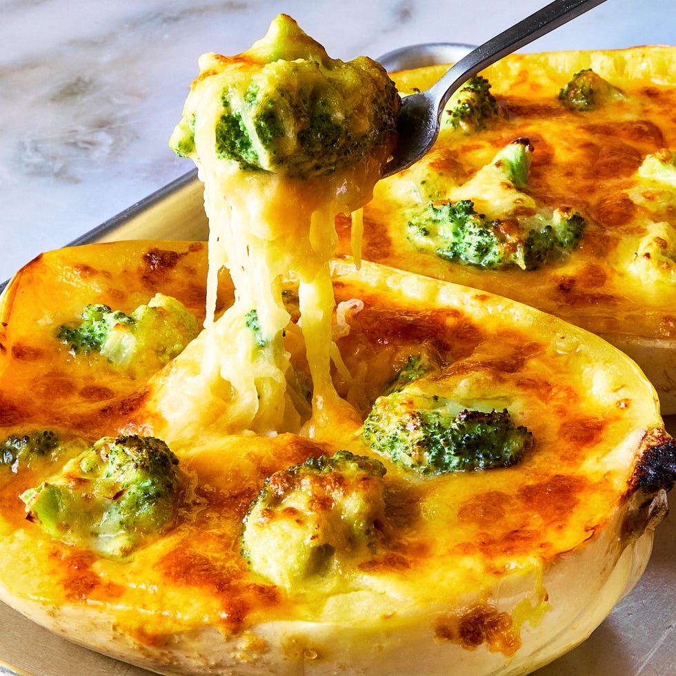 a fork lifting cheesy broccoli cheddar spaghetti squash from a stuffed spaghetti squash half