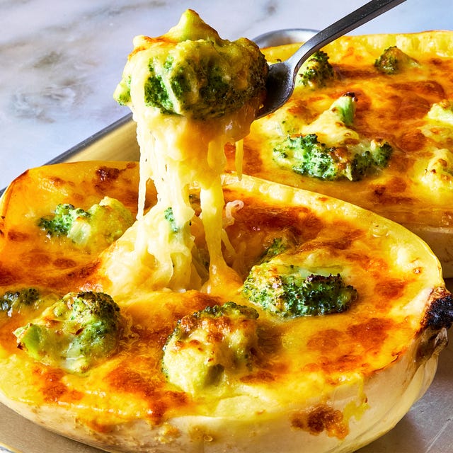 a fork lifting cheesy broccoli cheddar spaghetti squash from a stuffed spaghetti squash half