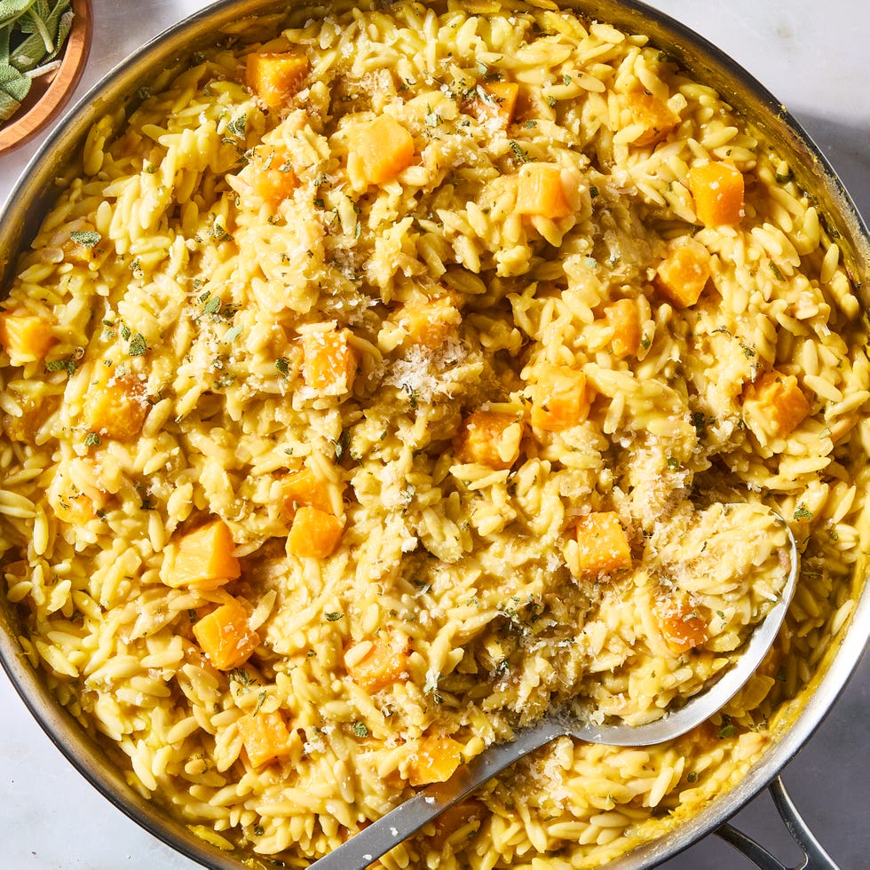 creamy butternut squash orzo in a pan topped with parmesan and herbs
