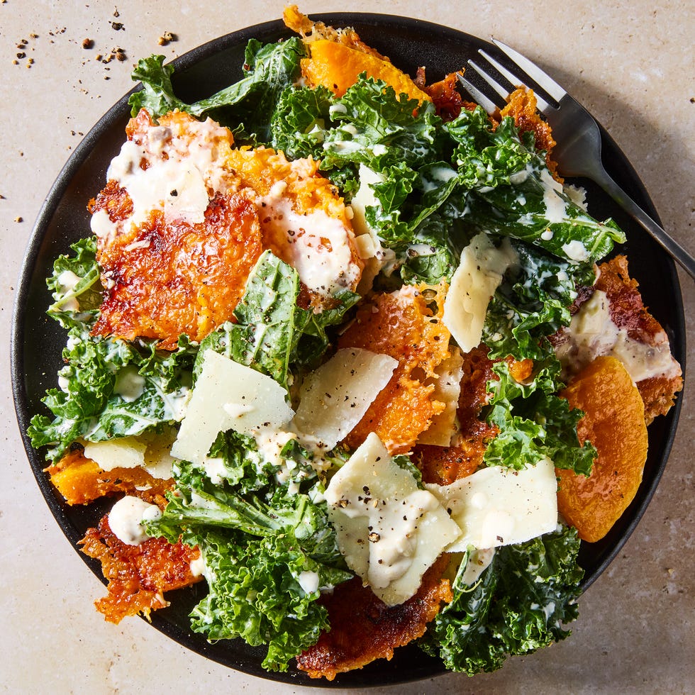 harvest caesar salad with squash croutons and parmesan on a black plate