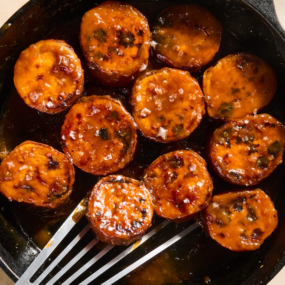 melting sweet potatoes in a cast iron skillet topped with miso maple butter glaze and flaky salt