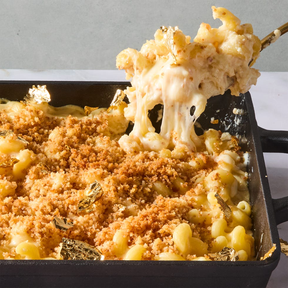 spoon lifting mac and cheese topped with crispy breadcrumbs from a cast iron pan